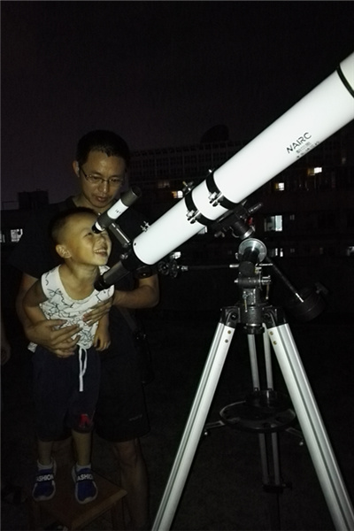 小朋友通过望远镜看月亮.jpg